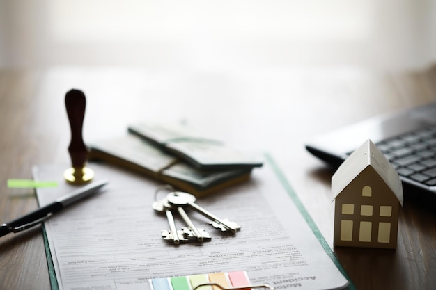 Model domu z agentem nieruchomości i klientem omawiającym umowę na zakup ubezpieczenia domu lub pożyczkę na tle nieruchomości