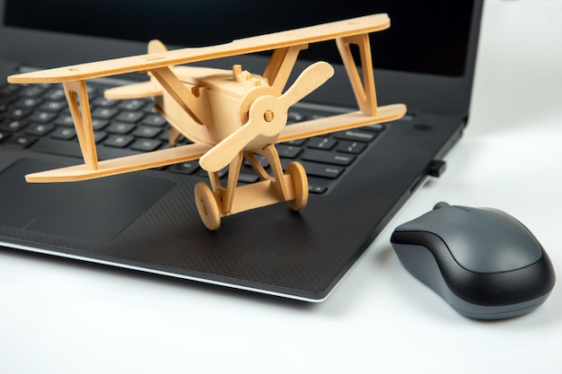 Zdjęcie model drewnianego samolotu na tle laptopa rozwój biznesu i sukces marzenie o lataniu w ulubionym biznesie