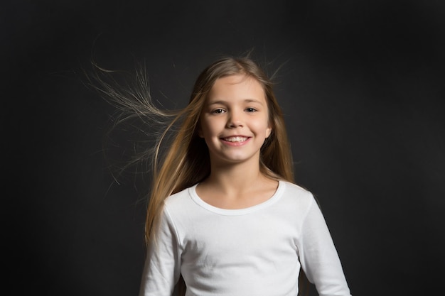 Model dziecka uśmiechający się z rozwianymi długimi włosami
