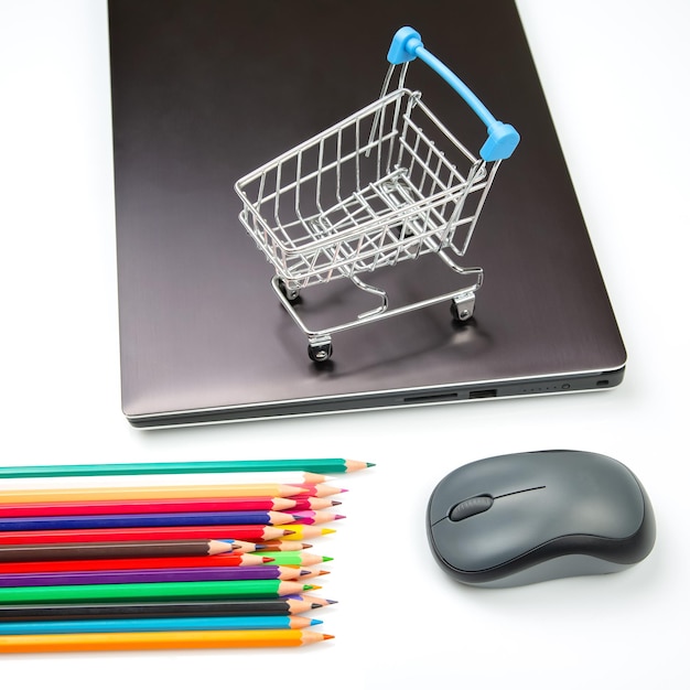Model wózka spożywczego z kolorowymi kredkami na tle laptopa Wyszukiwarka produktów Sklepy internetowe z zakupami online