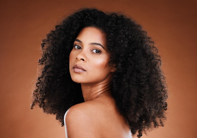Modelka czarna kobieta i włosy afro z makijażem kosmetycznym i odnowy biologicznej w estetycznym portrecie do samoopieki kosmetycznej Pielęgnacja włosów kobiety i twarz kosmetyków z naturalnymi kręconymi włosami na tle studia