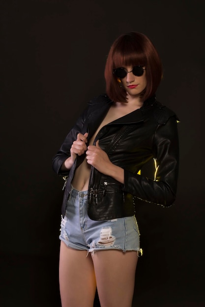 Zdjęcie modelka w okularach przeciwsłonecznych i czarnej skórzanej kurtce