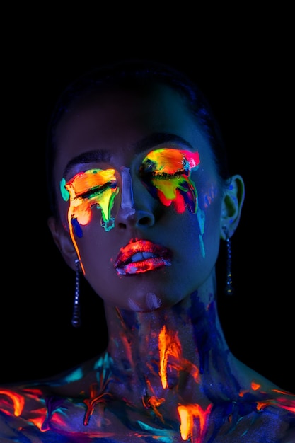 Modelka w świetle neonowym z farbą fluorescencyjną.