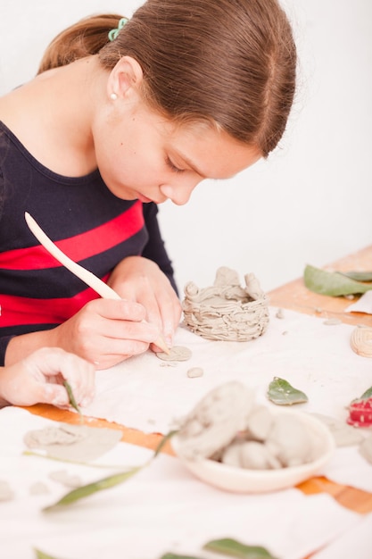 Zdjęcie modelowanie figur procesowych z plasteliny. nastolatka tworzy figurki z gliny