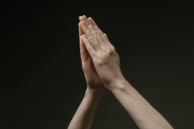 Modląc ręce do Boga w ciemności. Kobiece ręce wyciągające się do Boga lub o pomoc w stylu barokko