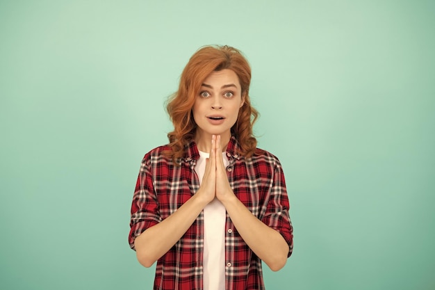 Zdjęcie modląca się ruda kobieta z kręconymi włosami w kraciastej koszuli na co dzień modli się