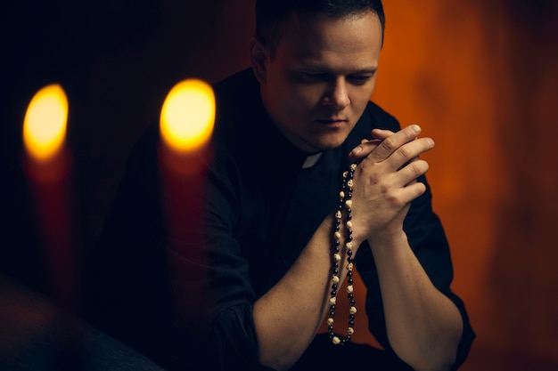 Modlący się kapłan. Portret księdza Obok modli się świeca