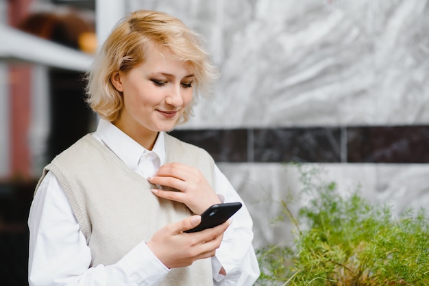 Zdjęcie modna kobieta rozmawia przez telefon w kawiarni na świeżym powietrzu