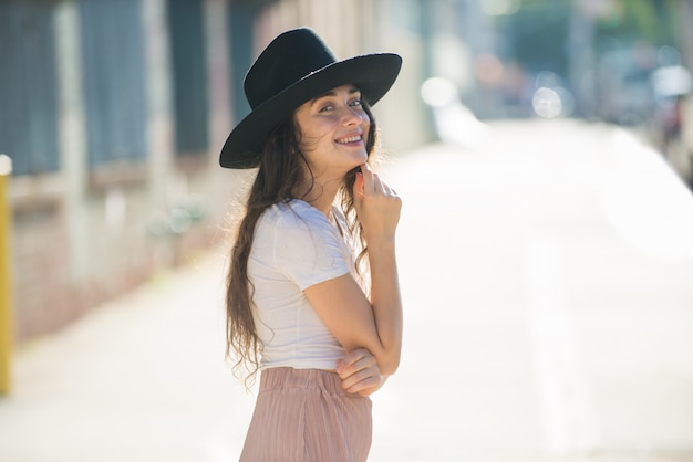 Modna piękna nastolatek kobieta pozuje z kapeluszem