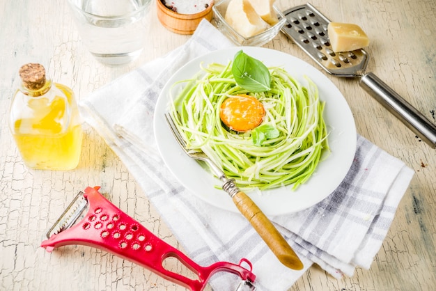 Modne Wegańskie Przepisy Kulinarne, Serowy Makaron Spaghetti Z Cukinii Z żółtkiem Jajka Z Parmezanem, Oliwą Z Oliwek I Liśćmi Bazylii, Jasna Betonowa Tło