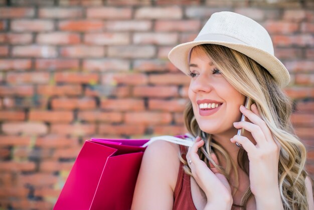 Modnej kobieta rozmawia przez telefon. Piękne kobiety spędzania czasu w mieście. Letnie zakupy