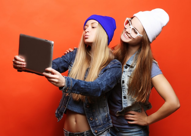 Modniś dziewczyn przyjaciele bierze selfie z cyfrową pastylką