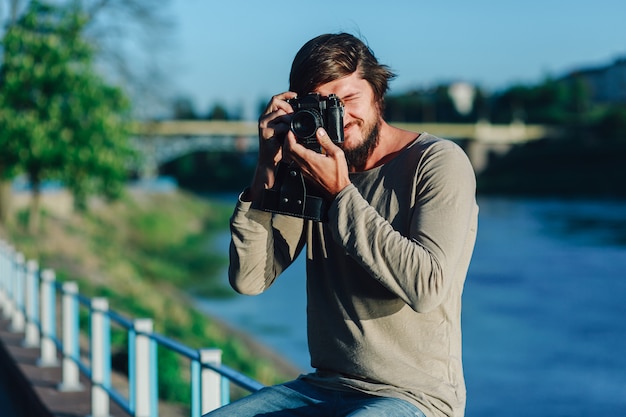 Modnisia mężczyzna bierze fotografię na retro kamerze plenerowej