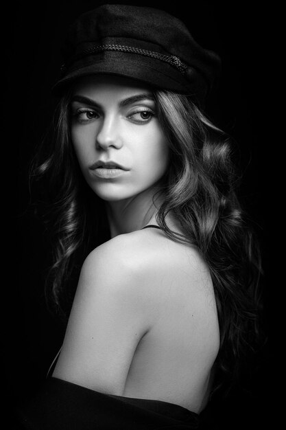 Modny portret studyjny pięknej młodej modelki w czarnym kapeluszu