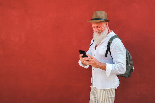 Modny starszy mężczyzna za pomocą aplikacji na smartfony