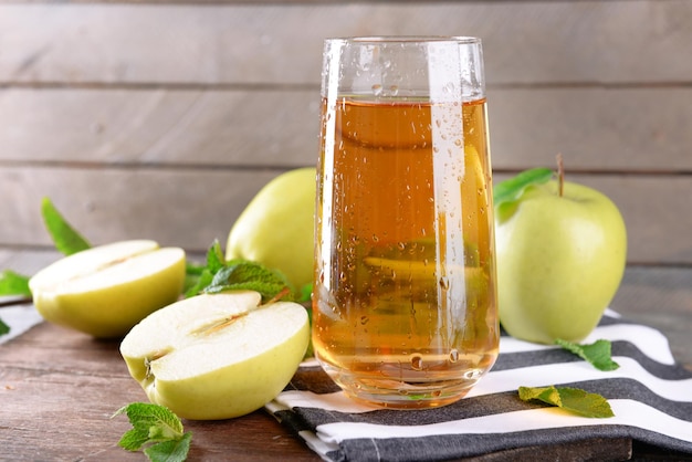 Zdjęcie mokra szklanka soku jabłkowego na podłoże drewniane