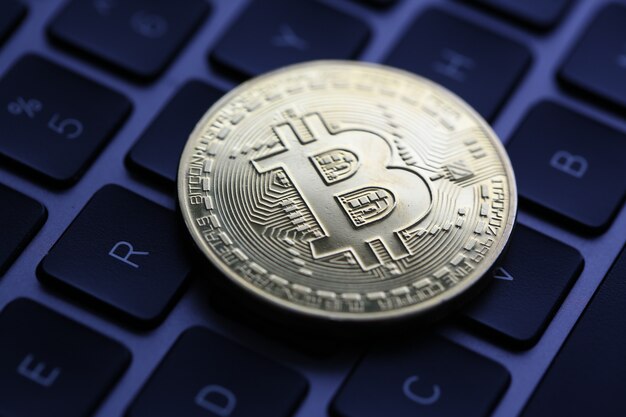 Moneta Bitcoin kryptowaluty leży na klawiaturze