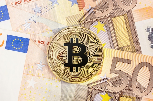 Moneta Bitcoin na tle banknotów euro