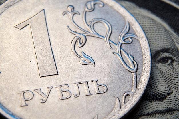 Moneta o nominale 1 rubla leży na banknocie zbliżenia dolara amerykańskiego