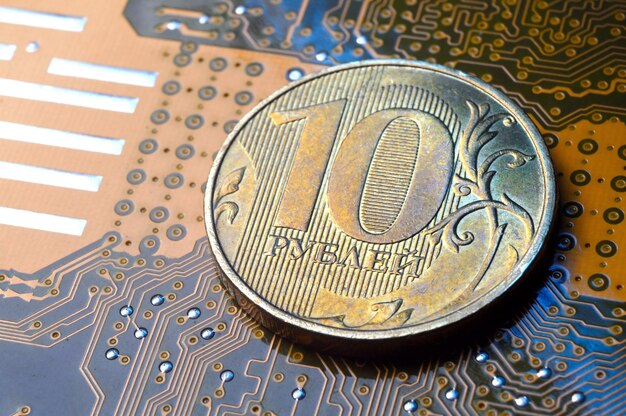 Moneta o wartości nominalnej 10 rubli leży na zbliżeniu mikroukładu Tłumaczenie napisu na monecie „10 rubli” Pojęcie gospodarki cyfrowej w Federacji Rosyjskiej