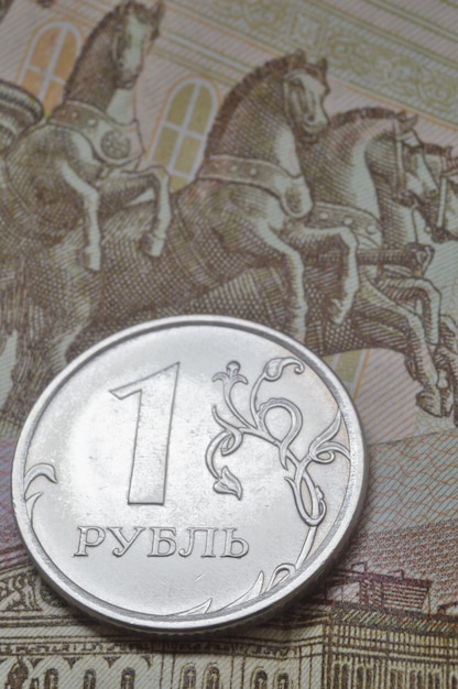 Moneta rosyjska o nominale 1 rubla leży na banknocie Tłumaczenie napisów na monecie quot1 rublequot