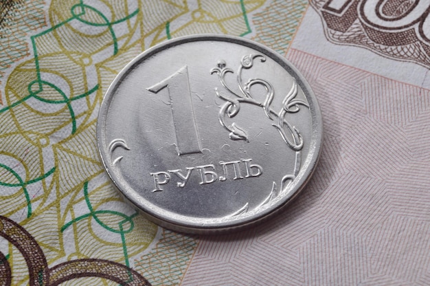 Moneta rosyjska o nominale 1 rubla leży na banknocie Tłumaczenie napisów na monecie quot1 rublequot
