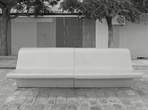Monochromatyczna pusta betonowa ławka na Miejskim chodniczku
