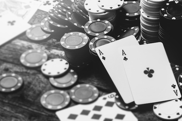 Monochromatyczny obraz dwóch asów i wielu żetonów w kasynie