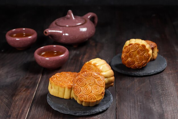 Moon cake Mooncake ustawienie stołu - Okrągłe chińskie tradycyjne ciasto z filiżankami herbaty na stole.