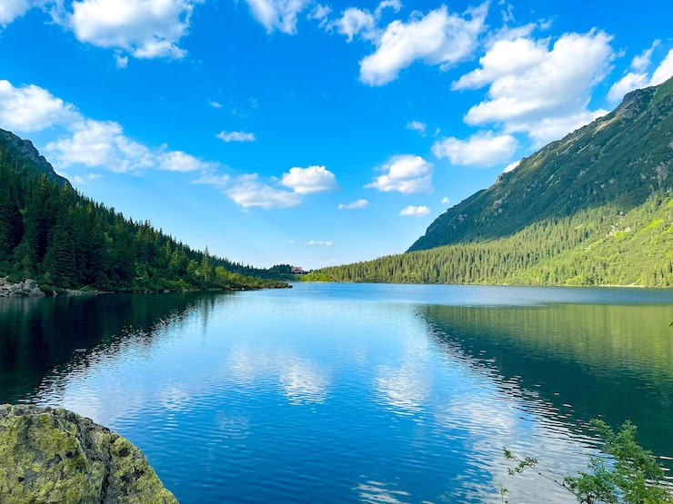 Zdjęcie morskie oko jezioro w górach zielona trawa wodospad i słońce