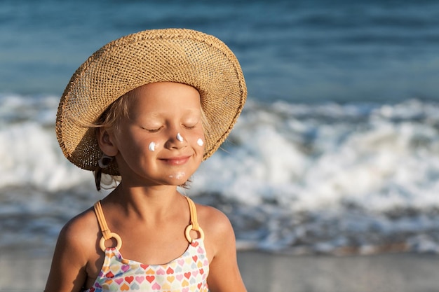 Morze Dzieci Wakacje Opalone Dziecko opalające się z filtrem przeciwsłonecznym na twarzy na tle morza
