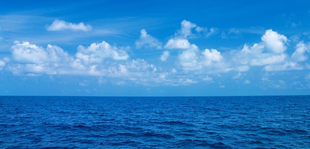 Morze i błękitne niebo Błękitna woda morska i niebo z białymi puszystymi chmurami Poziome tło błękitnego morza Tropikalny krajobraz