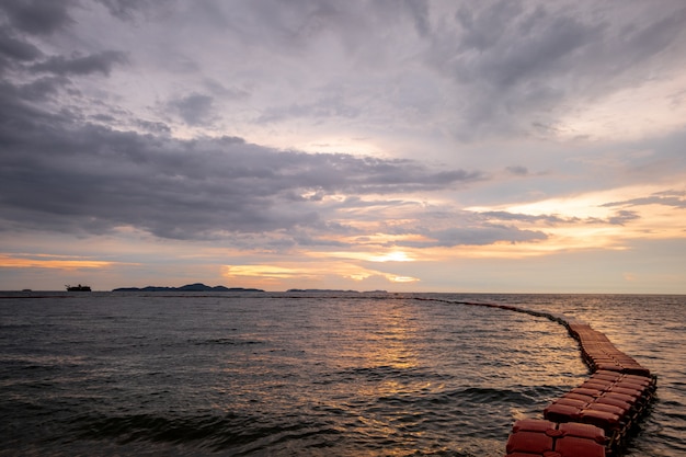 Morze i zachód słońca z widokiem czerwonej boi na strefę bezpiecznego pływania