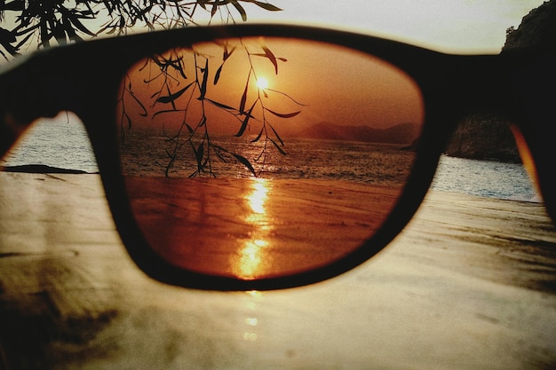 Zdjęcie morze widziane przez okulary przeciwsłoneczne podczas zachodu słońca