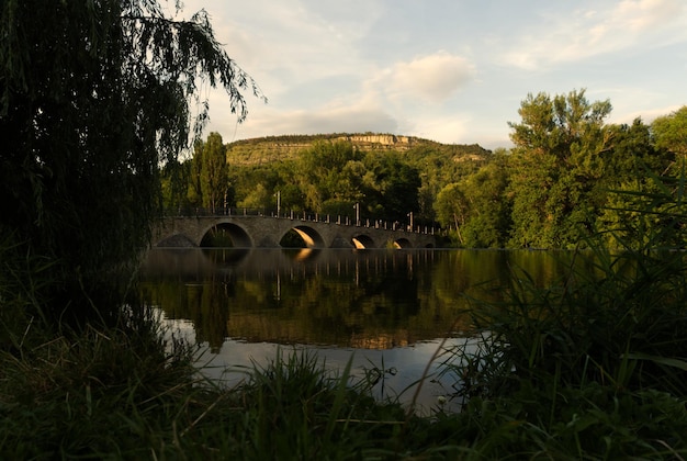 Zdjęcie most łukowy nad jeziorem na tle nieba