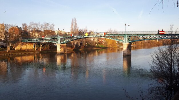 Zdjęcie most łukowy nad rzeką na tle nieba w mieście