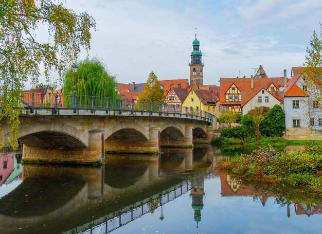 Zdjęcie most łukowy nad rzeką przez budynki na tle nieba