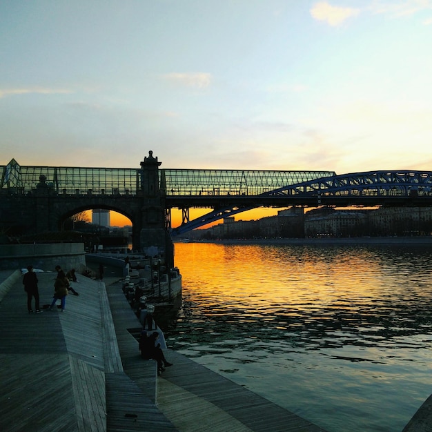 Zdjęcie most nad rzeką na tle nieba podczas zachodu słońca