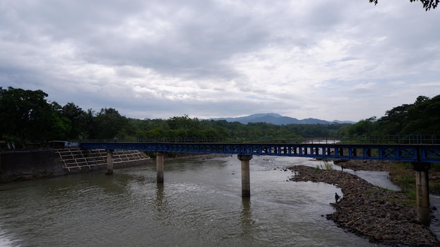 Most nad rzeką z górami w tle