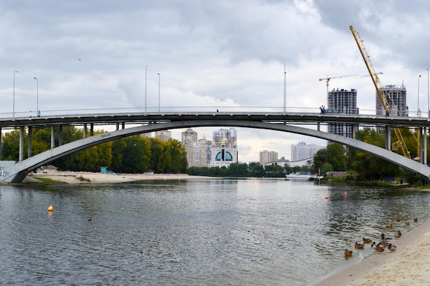 Most nad rzeką z kaczkami na tle budowy