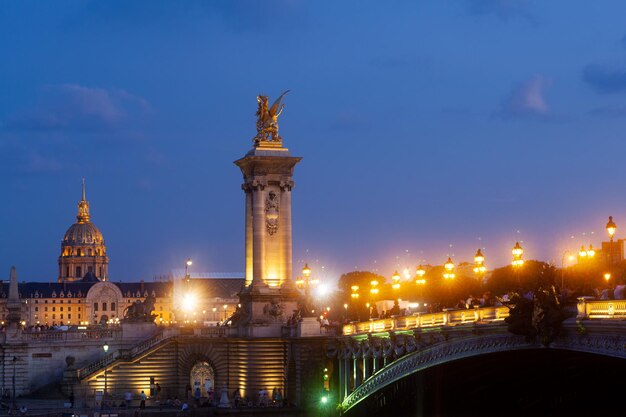 Most Pont Alexandre III i oświetlone latarnie o zachodzie słońca 7. Dzielnica Paryż Francja