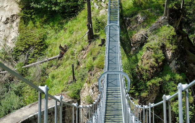 Most wiszący między drzewami w Alpach w Kals am Grossglockner w Austrii