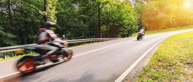 motocykle na leśnej drodze jeżdżą szybko. zabawy z jazdy pustą drogą podczas wycieczki motocyklowej. copyspace dla Twojego indywidualnego tekstu.