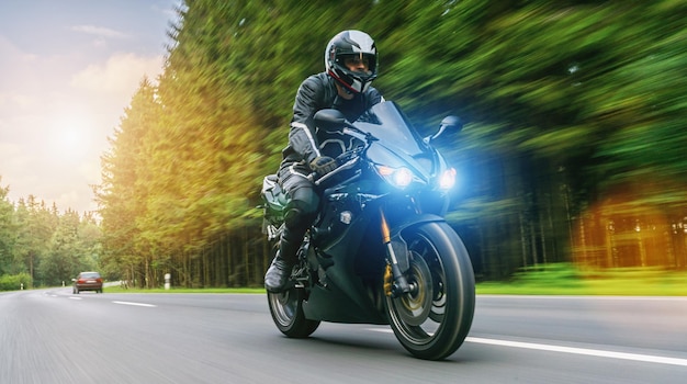 Motocyklista na leśnej drodze jedzie dobrze się bawiąc jeżdżąc pustą drogą podczas wycieczki motocyklowej