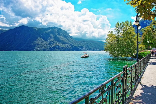 Motorówka na nabrzeżu luksusowego kurortu w Lugano nad jeziorem Lugano i Alpami w kantonie Ticino w Szwajcarii.