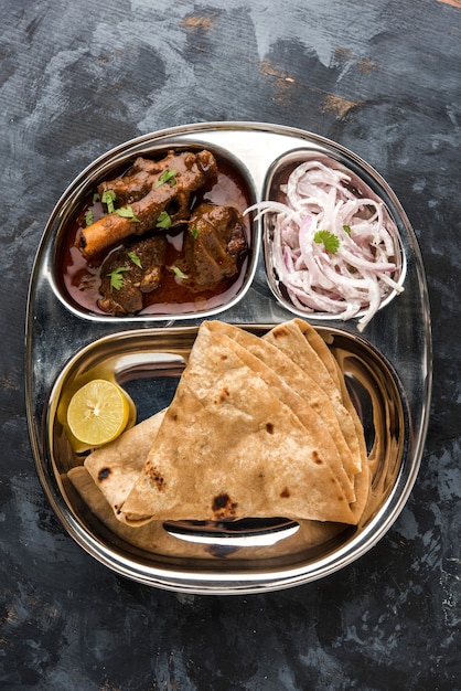 Motton Thali OR Gosht, półmisek jagnięcy to indyjskie azjatyckie menu na lunch lub kolację składa się z mięsa, jajka curry z chapati, ryżu, sałatki i słodkiego Gulab Jamun