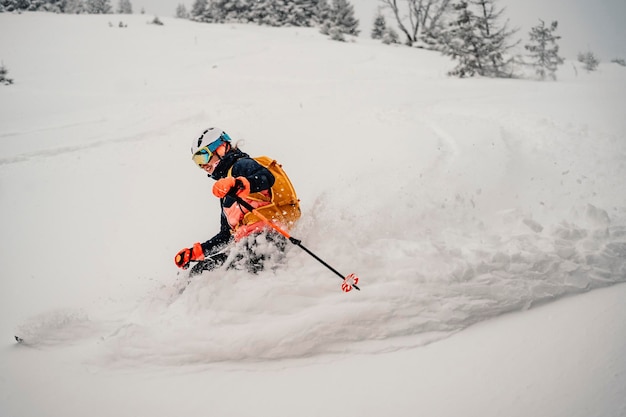 Mountaineer backcountry ski walking na nartach kobieta alpinistka w górach Skialpinizm w alpejskim krajobrazie z ośnieżonymi drzewami Przygoda sporty zimowe Freeride narty