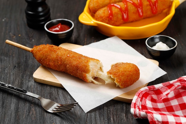 Mozarella Corndog z sosem pomidorowym Popularne koreańskie i amerykańskie jedzenie uliczne na drewnianym stole