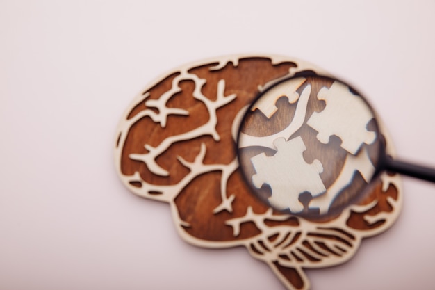 Mózg z drewnianymi puzzlami. Zdrowie psychiczne i problemy z pojęciem pamięci.