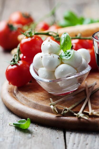 Mozzarella, pomidor i bazylia na drewnianym stole